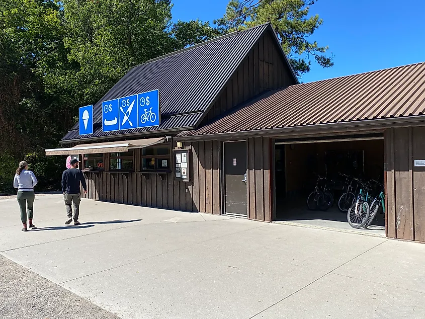 A couple approaches a park rental shop and ice cream shop.