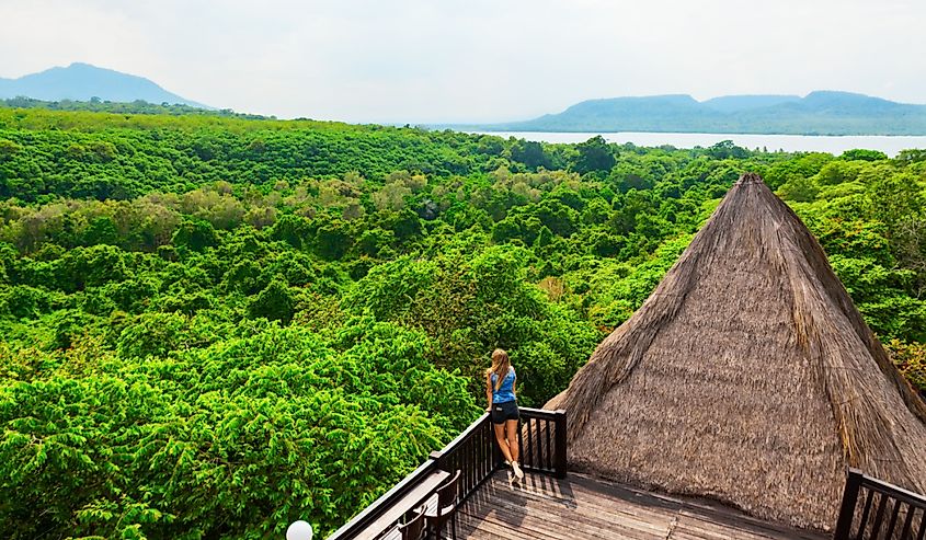 Young woman relax on lounge veranda with tropical jungle view in Bali.