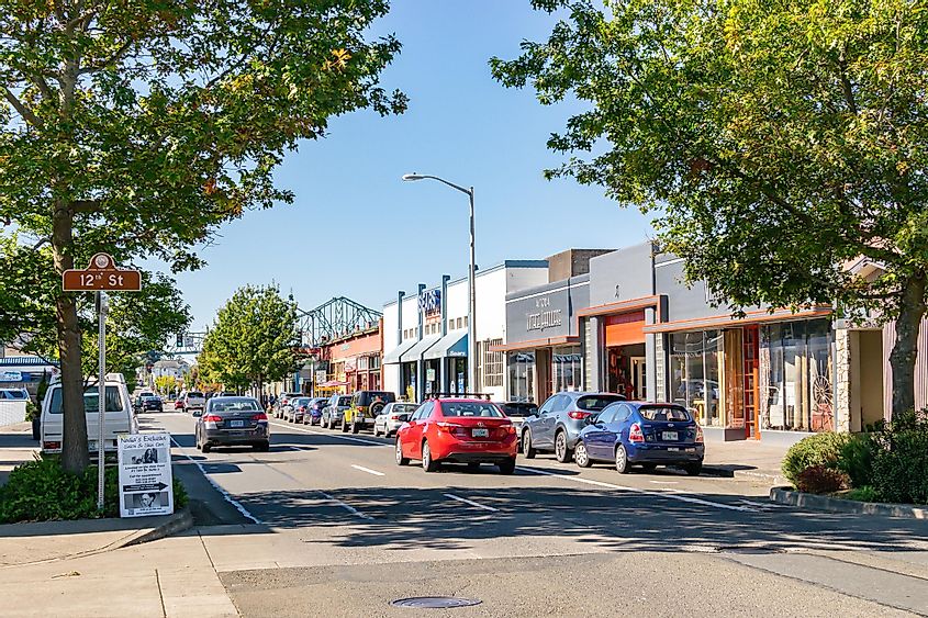 Cars on the street in downtown Astoria with Astoria-Megler Bridge in the background, via Enrico Powell / Shutterstock.com