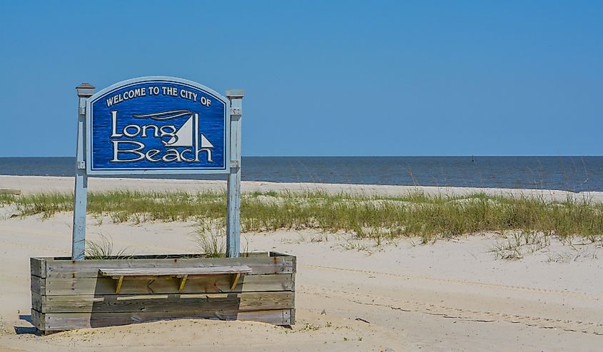 Welcome to Long Beach sign with view of coast in the background.