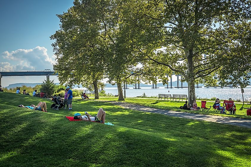 People relax on the lawn in the Hudson River Walk Park in Tarrytown, New York.