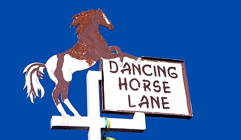 A metal street sign that says, "Dancing Horse Lane", with a horse in Corrales, New Mexico