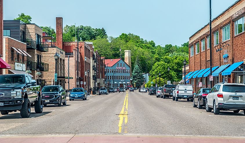 Street view of the downtown stores and restaurants in historic buildings and cars parked alongside on a sunny day in summer