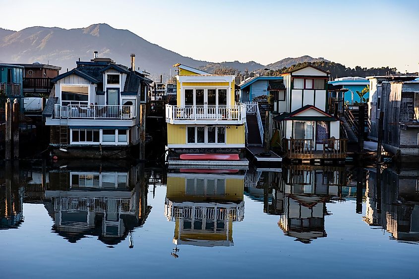 Colorful wooden house boats reflected into the still water of Richardson Bay in Sausalito, California.