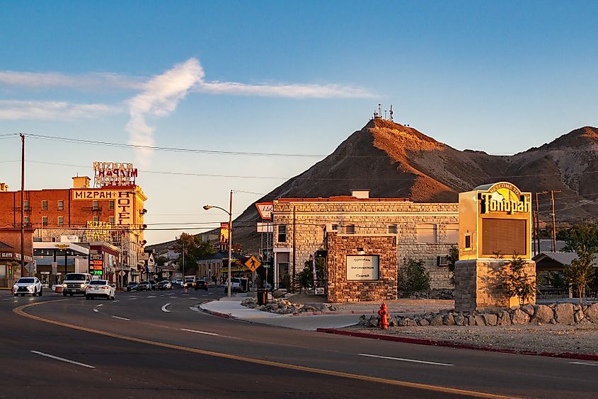 Sunset view down Main Street in Tonopah, Nevada, highlighting the historic Mizpah Hotel and the 'Welcome to Tonopah' sign, creating a picturesque scene along Highway 95.