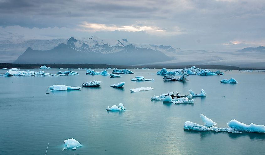 Luminous blue icebergs floating in Jokulsarlon glacial lagoon at dusk, Iceland