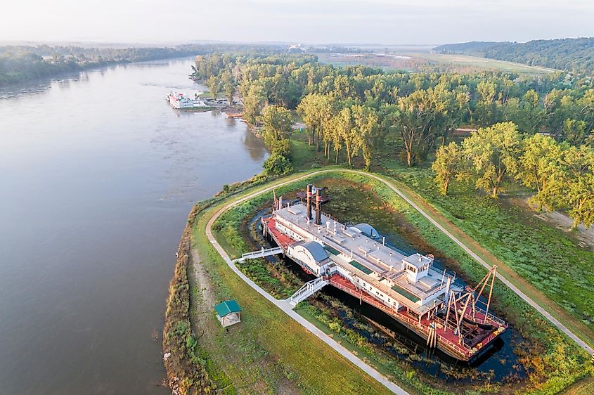 Hazy sunrise over the Missouri River in Brownville, Nebraska, USA, with the historic dredge "Captain Meriwether Lewis" in dry dock on the shore.