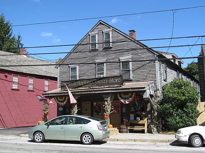 Exterior of the Brown and Hopkins Country Store in Chepachet, Rhode Island, with a rustic wooden facade, American flags, and vintage signage