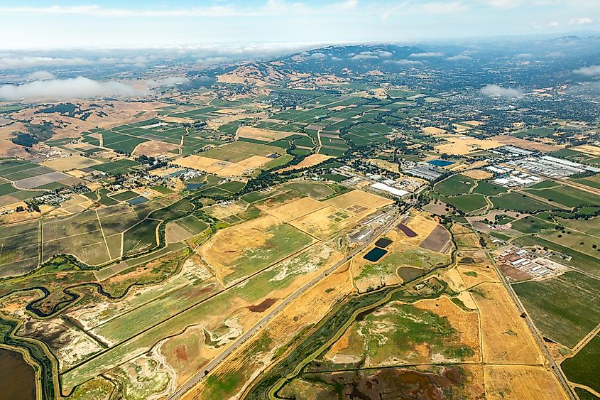 Aerial view of colorful patterns of agricultural fields and the wetlands of the Sacramento River Delta as it reaches the Northern San Francisco Bay