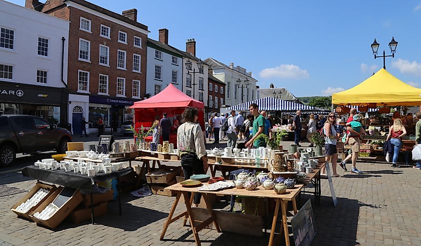 A sunny scene of people shopping in the centre of town market, Ludlow, Shropshire, England.