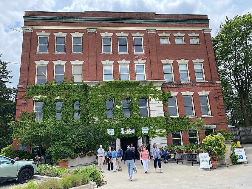 A red-brick building covered in ivy, with people coming in and out of the bookstore.