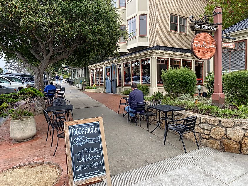 Sidewalk tables outside of a quaint coffee shop/bookstore. 