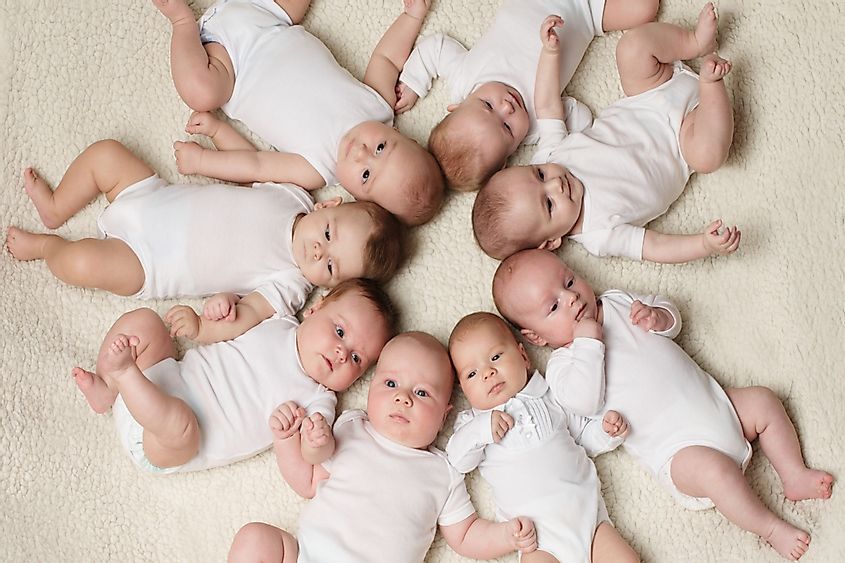Cute babies lying in a circle on light background