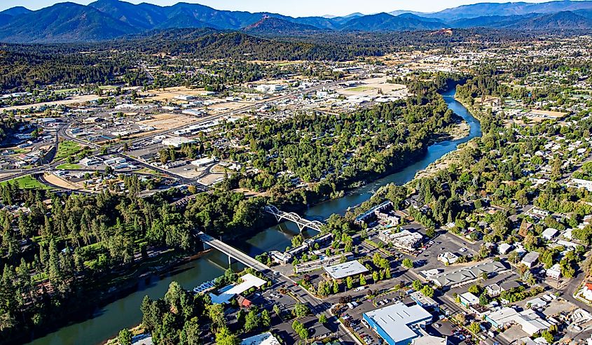 Aerial view of downtown Grants Pass with the Caveman concrete arch bridge and the 7th street bridge crossing the Rogue River