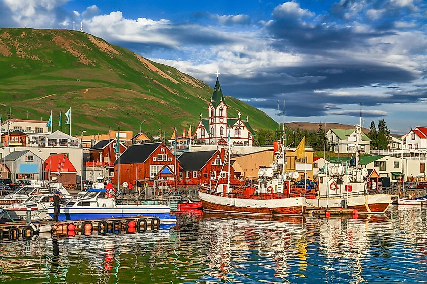 Beautiful view of the historic town of Husavik with traditional colorful houses and traditional fisherman boats lying in the harbor