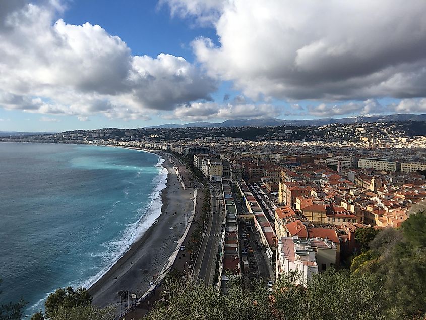 Nice, France as seen from high above. Clouds overhang the waterfront, and red-roofs of the old town. 