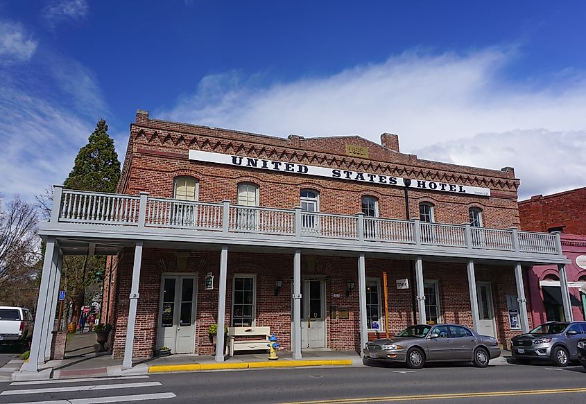 Underawesternsky via Shutterstock. Jacksonville, Oregon USA - March 28, 2019: Historic United States Hotel building in downtown historic district, built 1880, red brick construction. California Street at 3rd