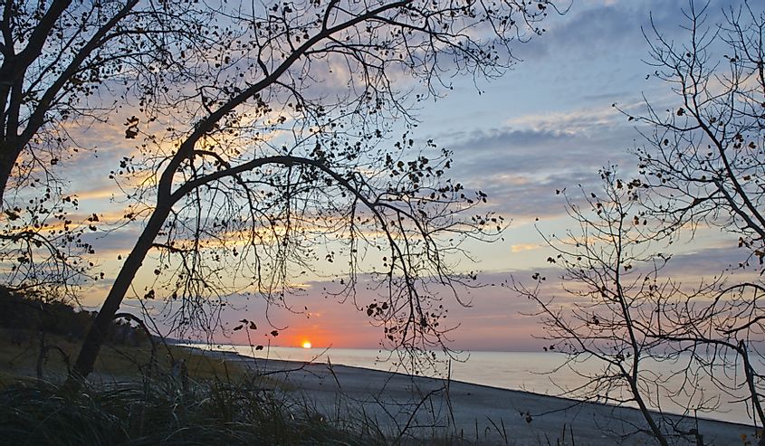 The sun sets to the west over the Lake Michigan Shore near Beverly Shores, Indiana