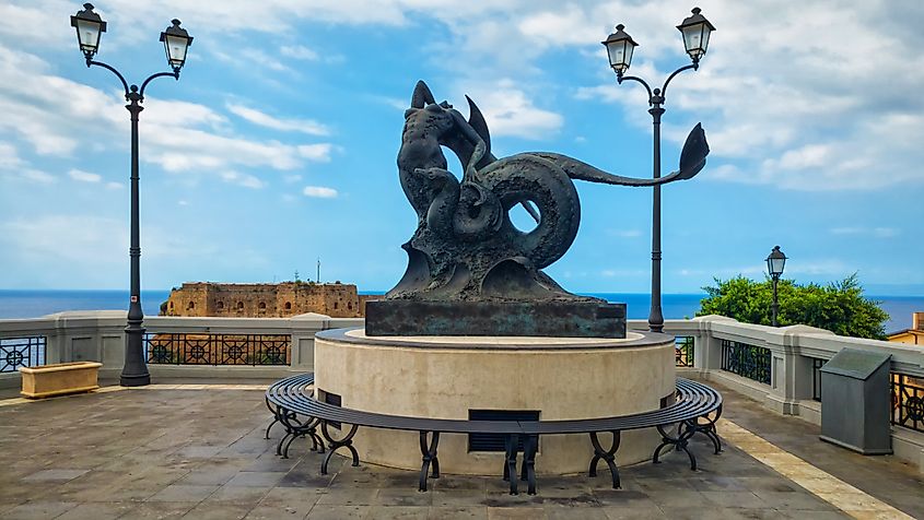 The statue of Scylla and Charybdis with view on ancient Ruffo castle.