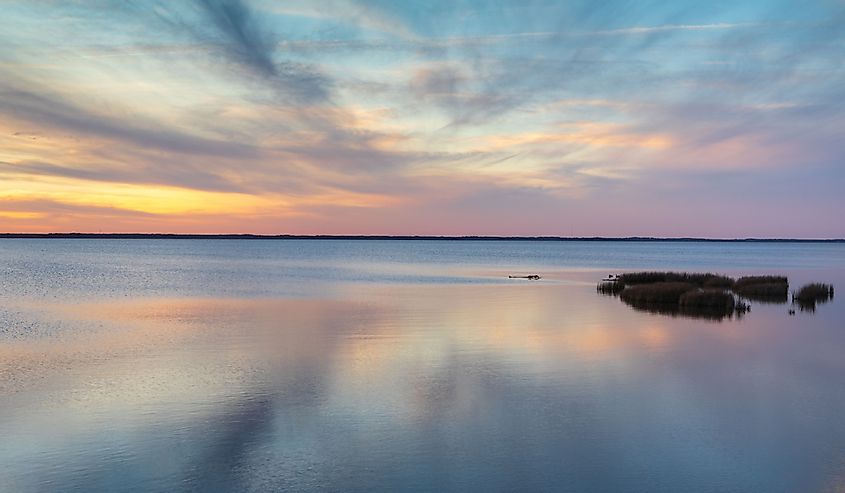 Seascape sunset background of blue sky and clouds reflecting in the water of the Currituck Sound on the outer banks of North Carolina