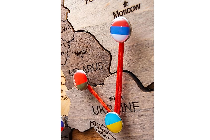 Pins with flags and red threads on wooden maps.