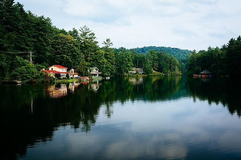 Trees and houses reflecting in Lake Sequoyah, Highlands, North Carolina