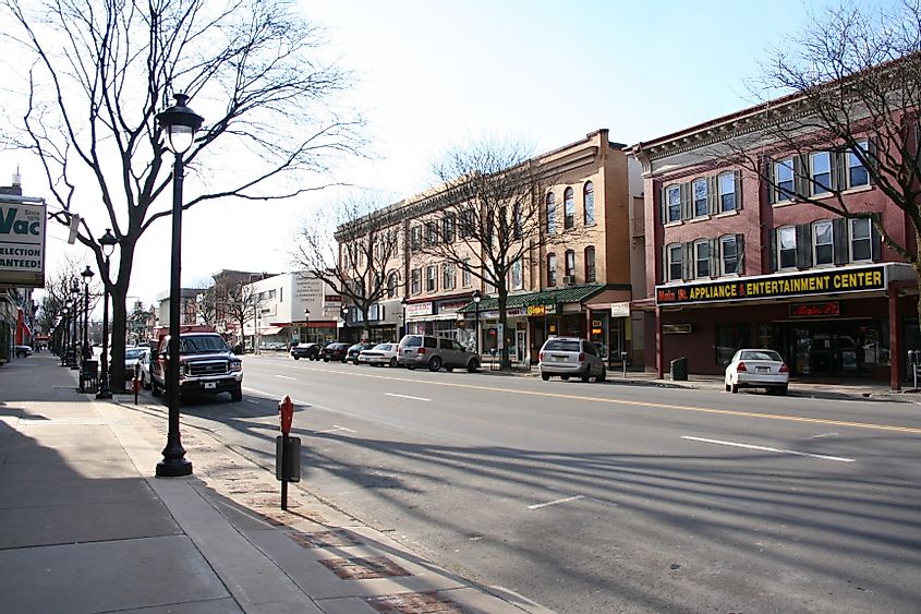 Historic Stroudsburg Main Street with shops, trees, cars, and lampposts.