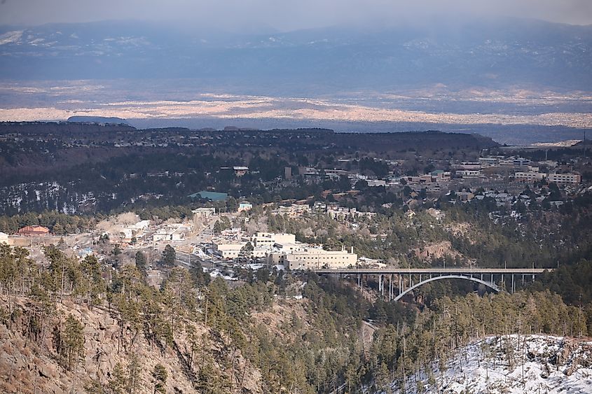 Elevated view over Los Alamos, New Mexico, with the Omega Bridge crossing Los Alamos Canyon visible in the lower right.