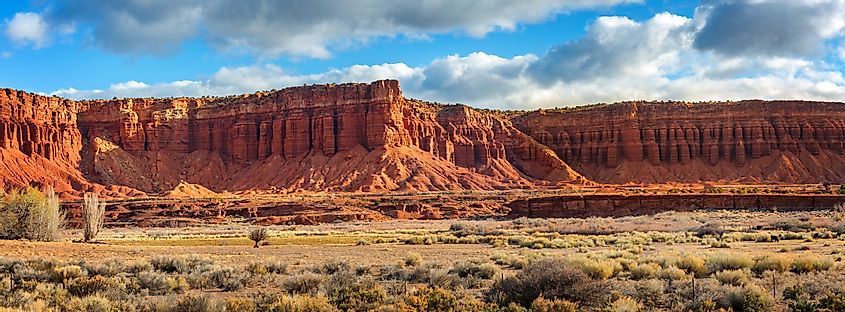 American Southwest desert landscape with iconic eroded Navajo sandstone bluffs and blue skies near Torrey, Utah.