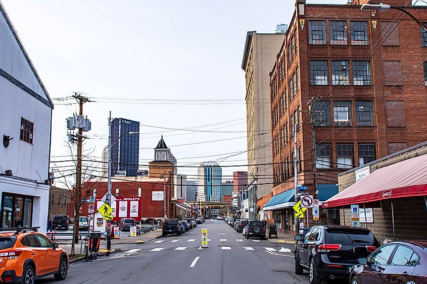 A street scene in the Strip District neighborhood along Penn Avenue, with downtown in the distance on an overcast winter day, via woodsnorthphoto / Shutterstock.com