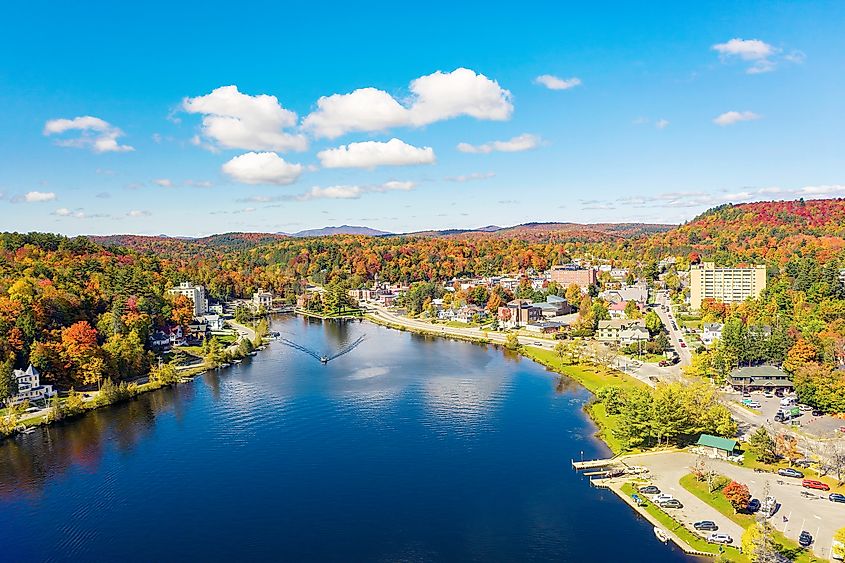 Aerial view of Saranac Lake, New York, showcasing vibrant fall colors in the Adirondack Mountains. 