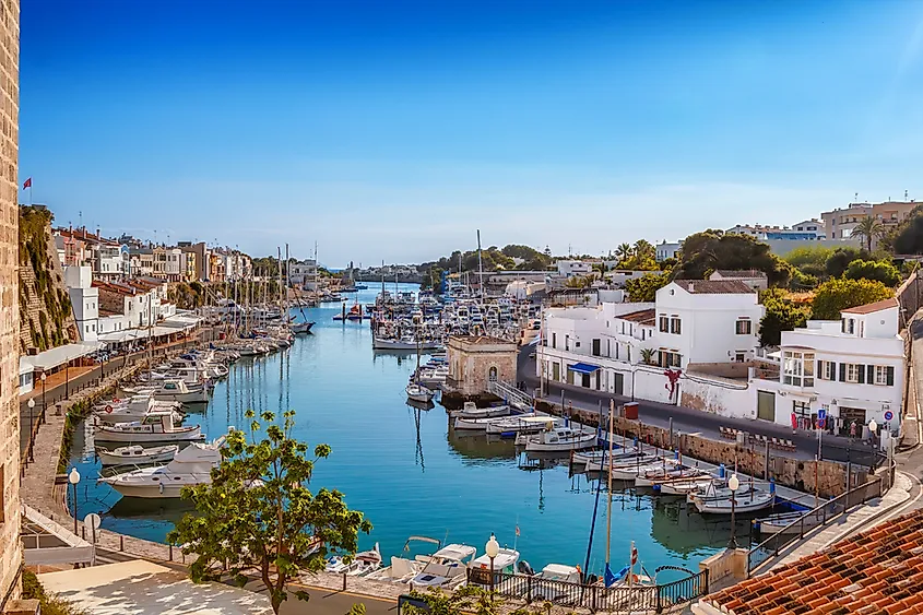 View on old town Ciutadella sea port on sunny day, Menorca, Spain. Via Shutterstock / tuulijumala