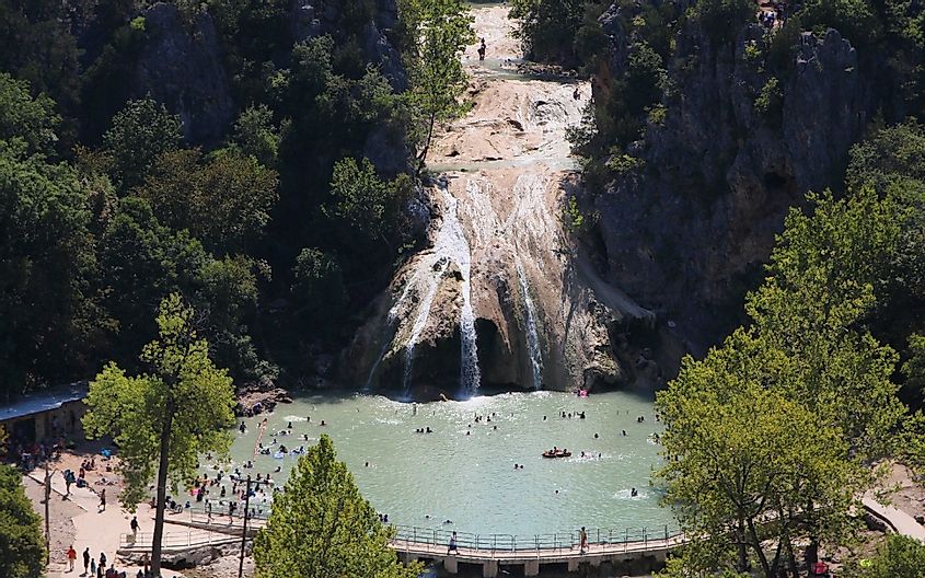 Overlooking Turner Falls, Oklahoma and people in the water on a hot summer day.
