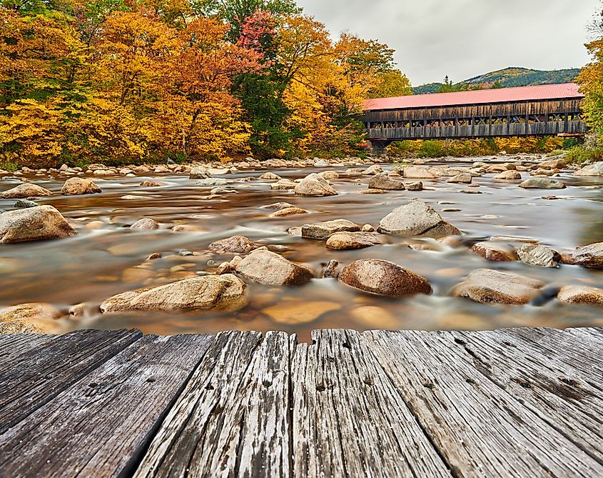 Swift River and old covered Albany Bridge at autumn in White Mountain National Forest, New Hampshire, USA. 