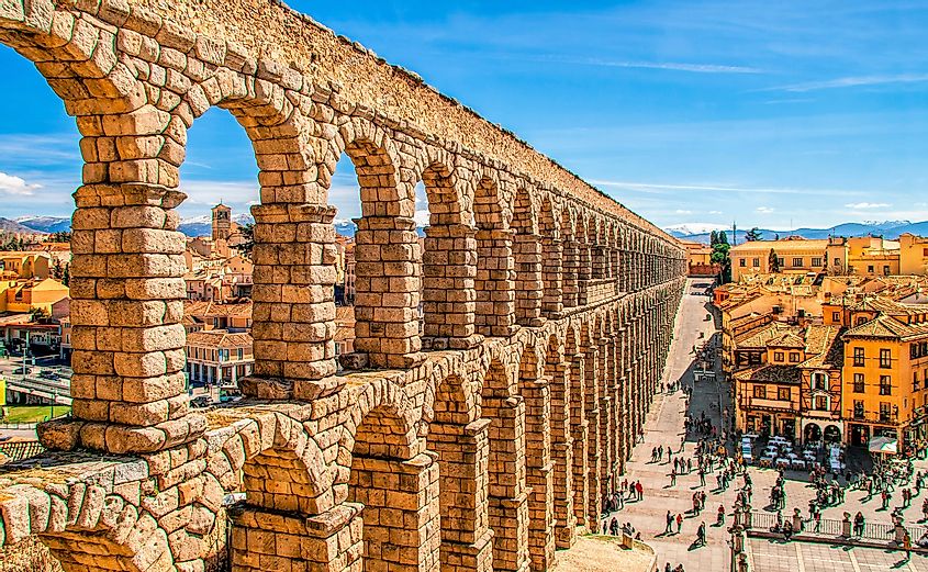 Ancient Roman aqueduct on Plaza del Azoguejo square and old building towns in Segovia, Spain.