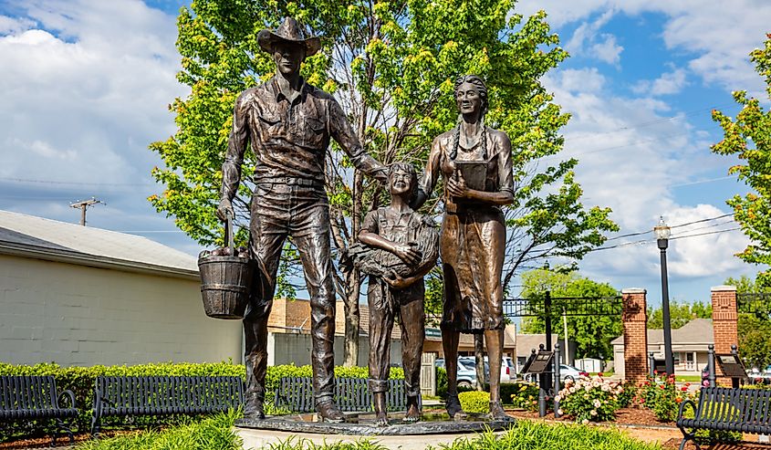 Bronze statue of an early 20th-century agriculture family, at Centennial Park on Main Street.