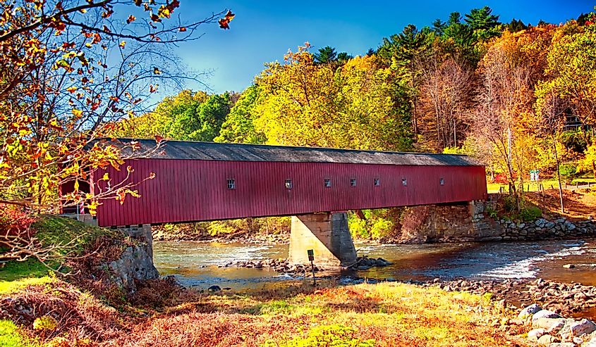 A iconic west cornwall covered bridge spanning the Housatanic River in Connecticut during the New England autumn