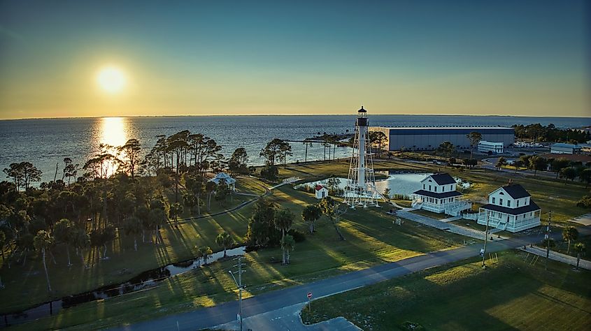 Setting sun behind Cape San Blas Lighthouse in Port St. Joe, Florida.