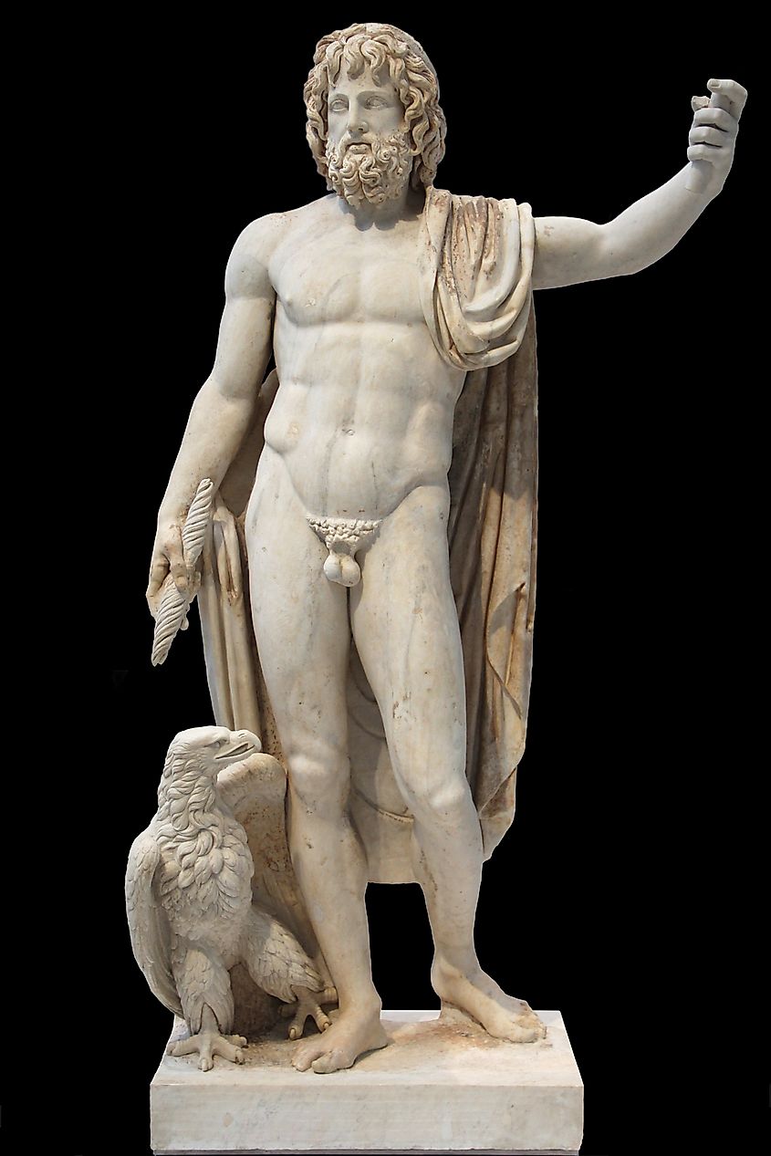 Marble statue of Jupiter standing nude with draped fabric, holding a thunderbolt and accompanied by an eagle at his side.