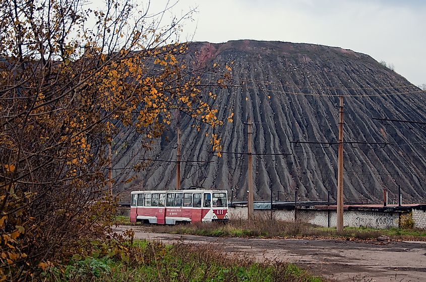 An old tram is running through the industrial zone with a spoil tip in the background in Horlivka, Ukraine.