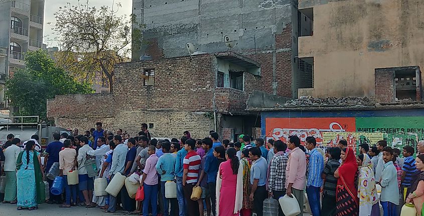 People queue for taking water from Delhi Jal board tanker in the early morning.