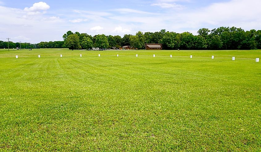 Poverty Point World Heritage Site in Louisiana is a prehistoric monumental earthworks site constructed by the Poverty Point culture. White markers indicate large post pits, rings of wood on the plaza