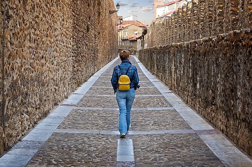 A tourist woman walks through the medieval wall of Leon, Spain