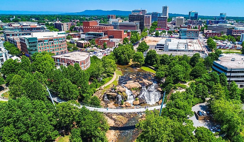 Downtown Greenville South Carolina skyline drone aerial of Falls Park and Liberty Bridge.