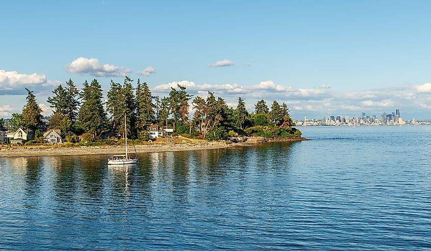 Boat on the water in front of Bainbridge Island with skyline of Seattle