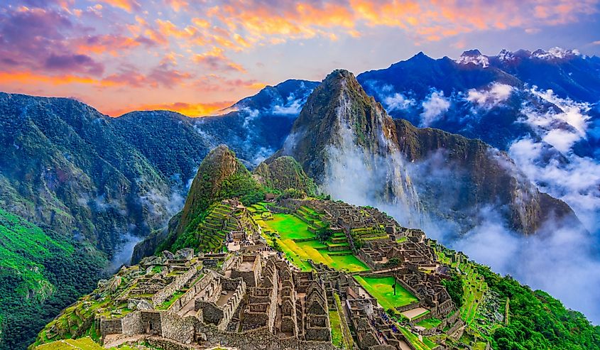 Overview of the lost inca city Machu Picchu, agriculture terraces and Wayna Picchu, peak in the background, before sunrise