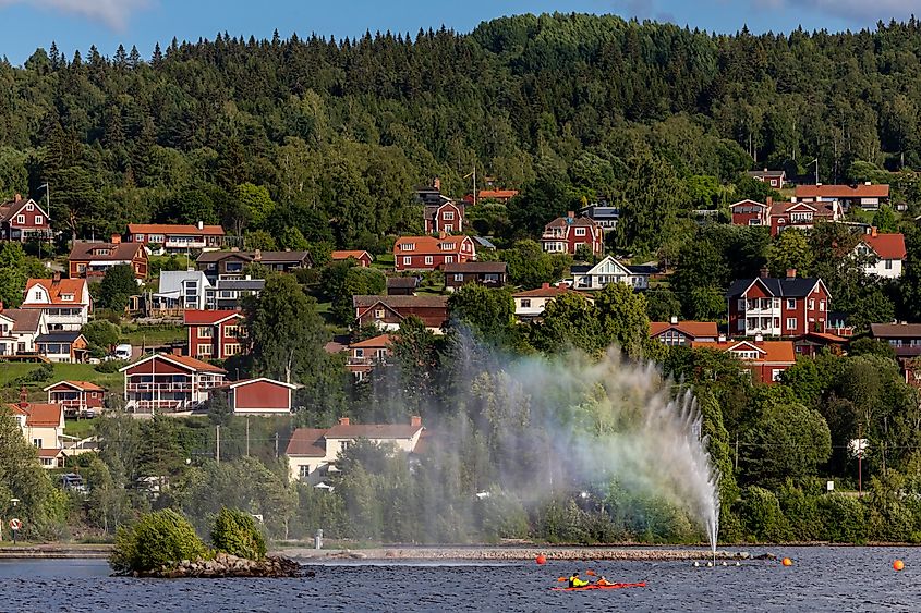 Kayakers pass the landmark fountain in Lake Siljan in Rattvik, Sweden