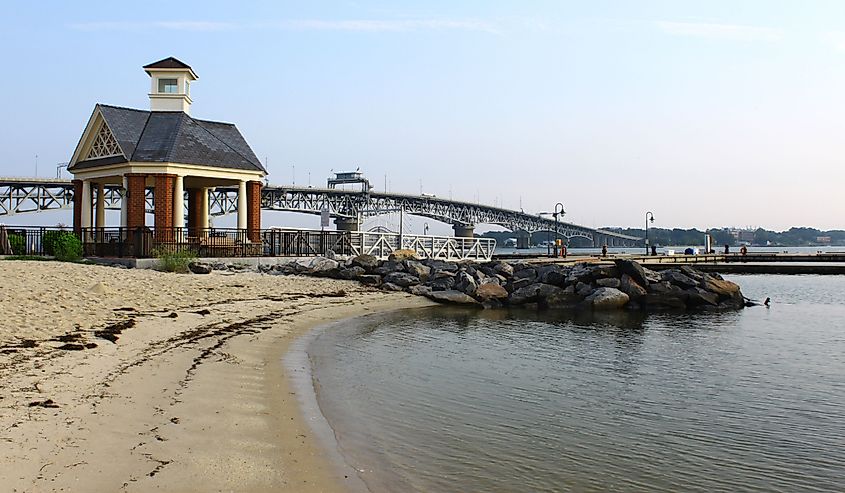 The Yorktown beach and waterfront with the Coleman bridge and a small gazebo type of building in the background on a summer day