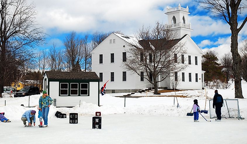 People gather on a frozen pond to ice skate and play hockey in New London, New Hampshire