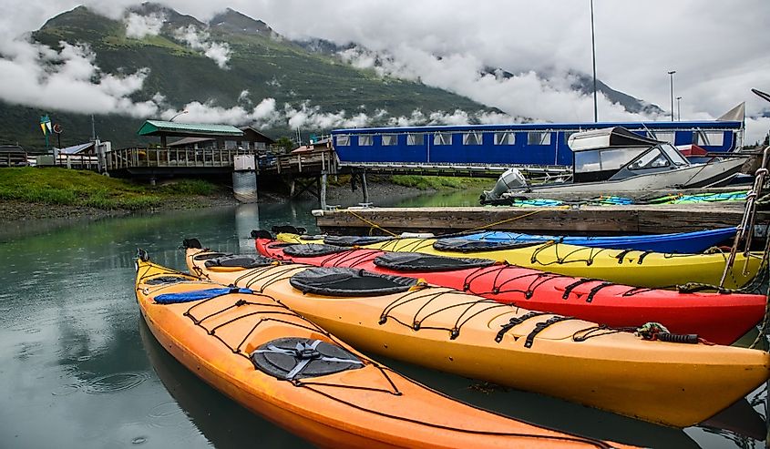 Double kayaks parked on the pier on scenic mountain ocean bay in Valdez, Alaska.